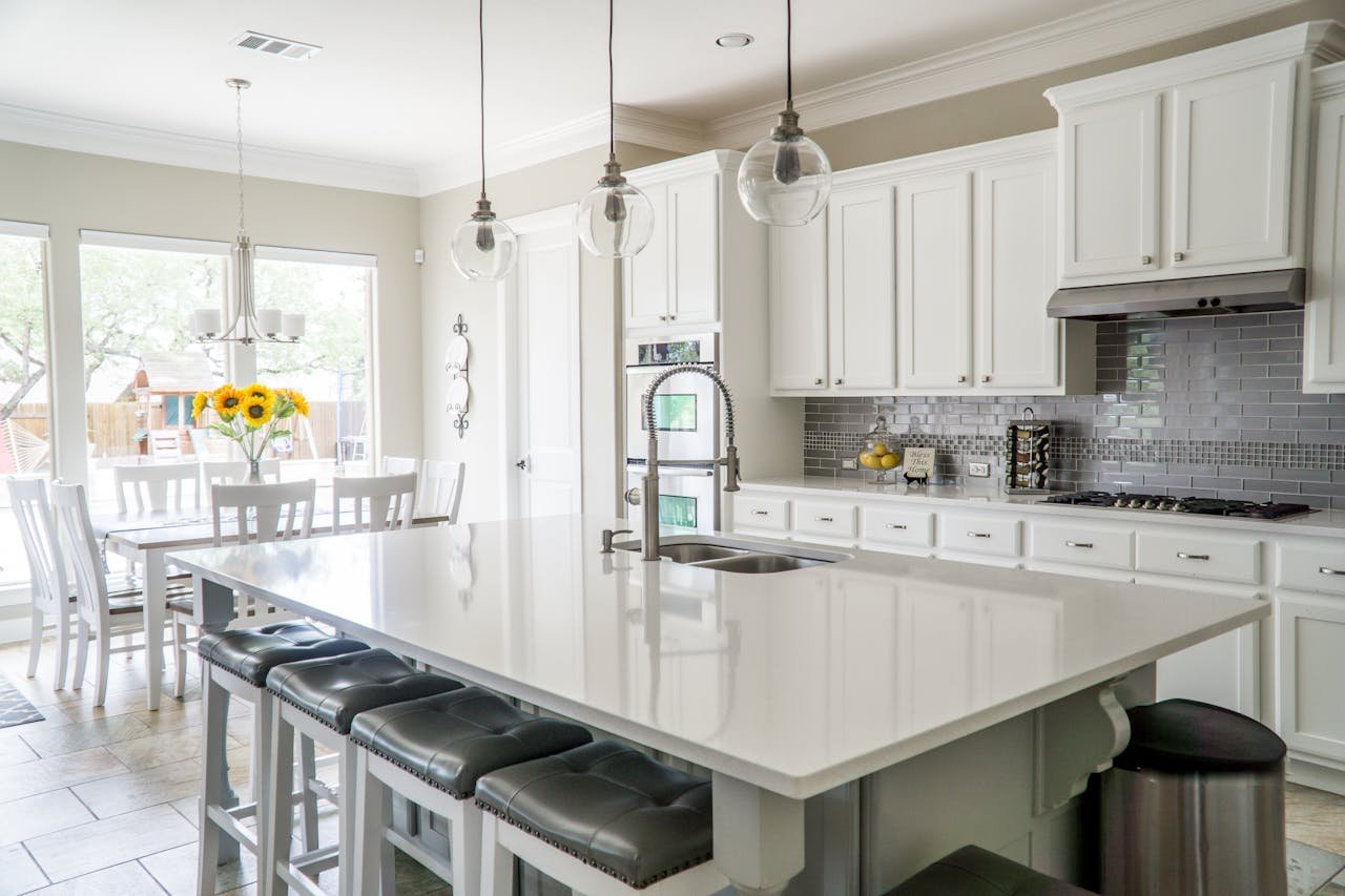 our-experience Spacious modern kitchen with white cabinets and island in natural light.
